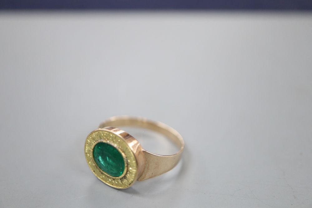 A yellow metal and oval cut foil backed emerald set ring,